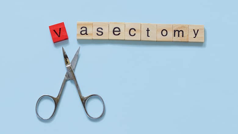 scrabble letters spelling out "Vasectomy" with scissors snipping off the letter V.